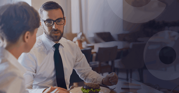Man talking to female coworker over lunch