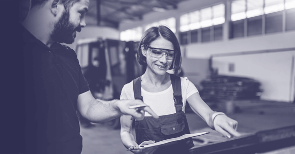 Female worker with safety glasses operating a machine