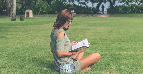 Woman sitting in a park and reading a book